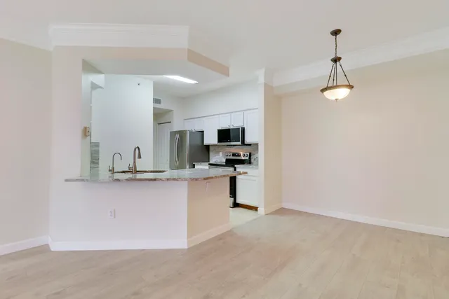 a kitchen with stainless steel appliances granite countertop a sink a stove top oven a counter space and cabinets