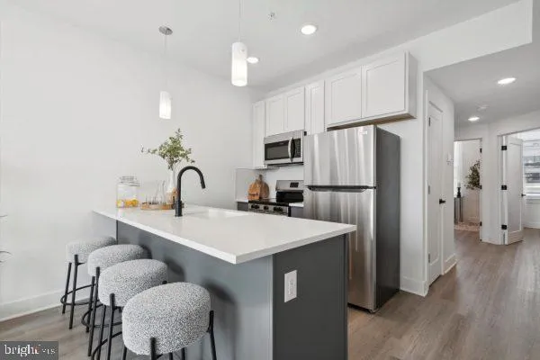 a kitchen with refrigerator and white cabinets