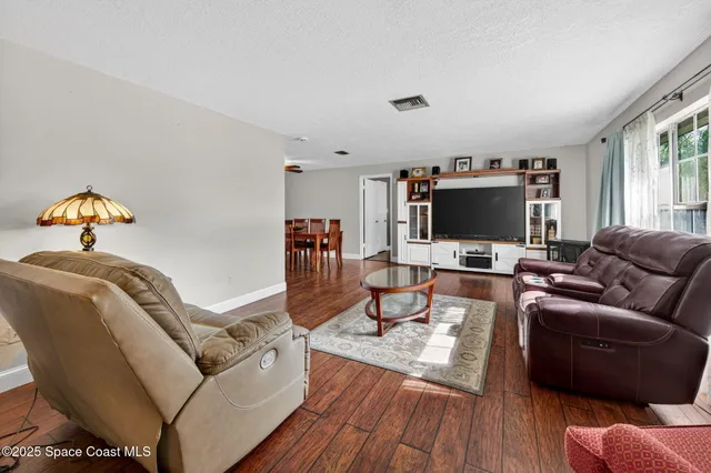 a living room with furniture and a wooden floor