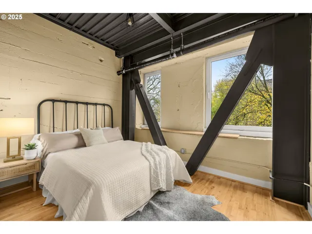a bedroom with a bed next to a large window