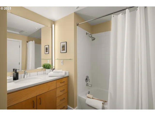 a bathroom with a double vanity sink mirror and shower