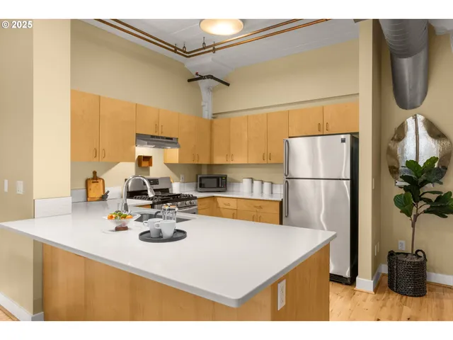 a kitchen with sink refrigerator dining table and chairs