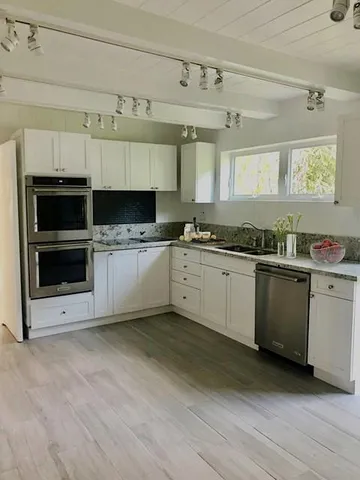 a white kitchen with a sink and a stove top oven