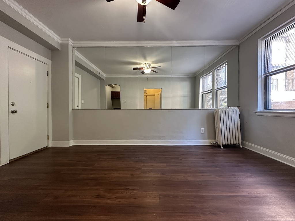 661 West Sheridan Road, Unit 208 Chicago, IL 60613 - Photo 14 of 20 a view of an empty room with wooden floor and a window