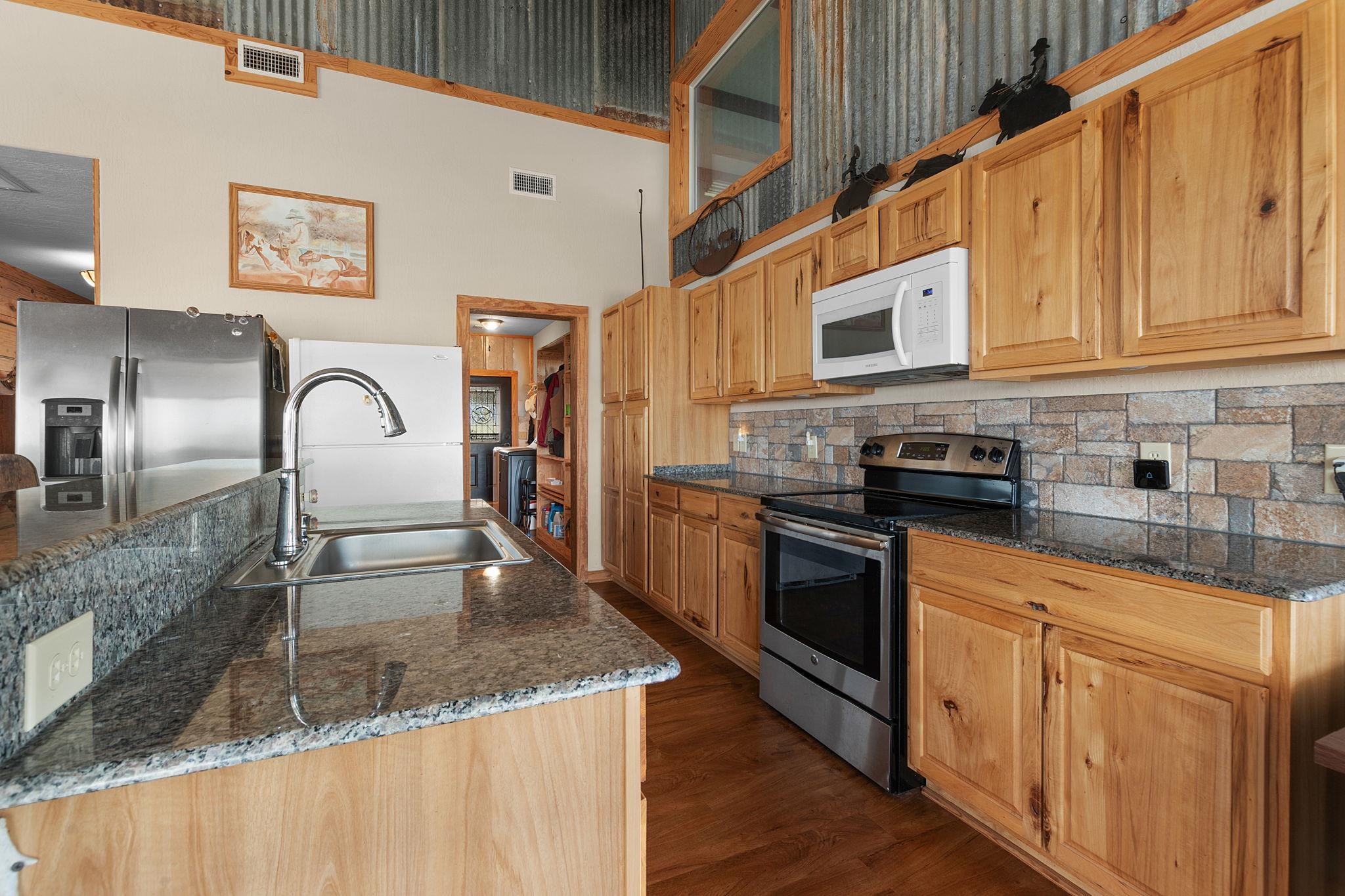 303 Lakeshore Loop Tow, TX 78672 - Photo 15 of 30 a kitchen with stainless steel appliances granite countertop a sink a stove and cabinets