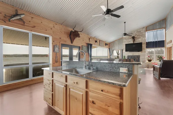 a living room with couches a flat screen tv and kitchen view
