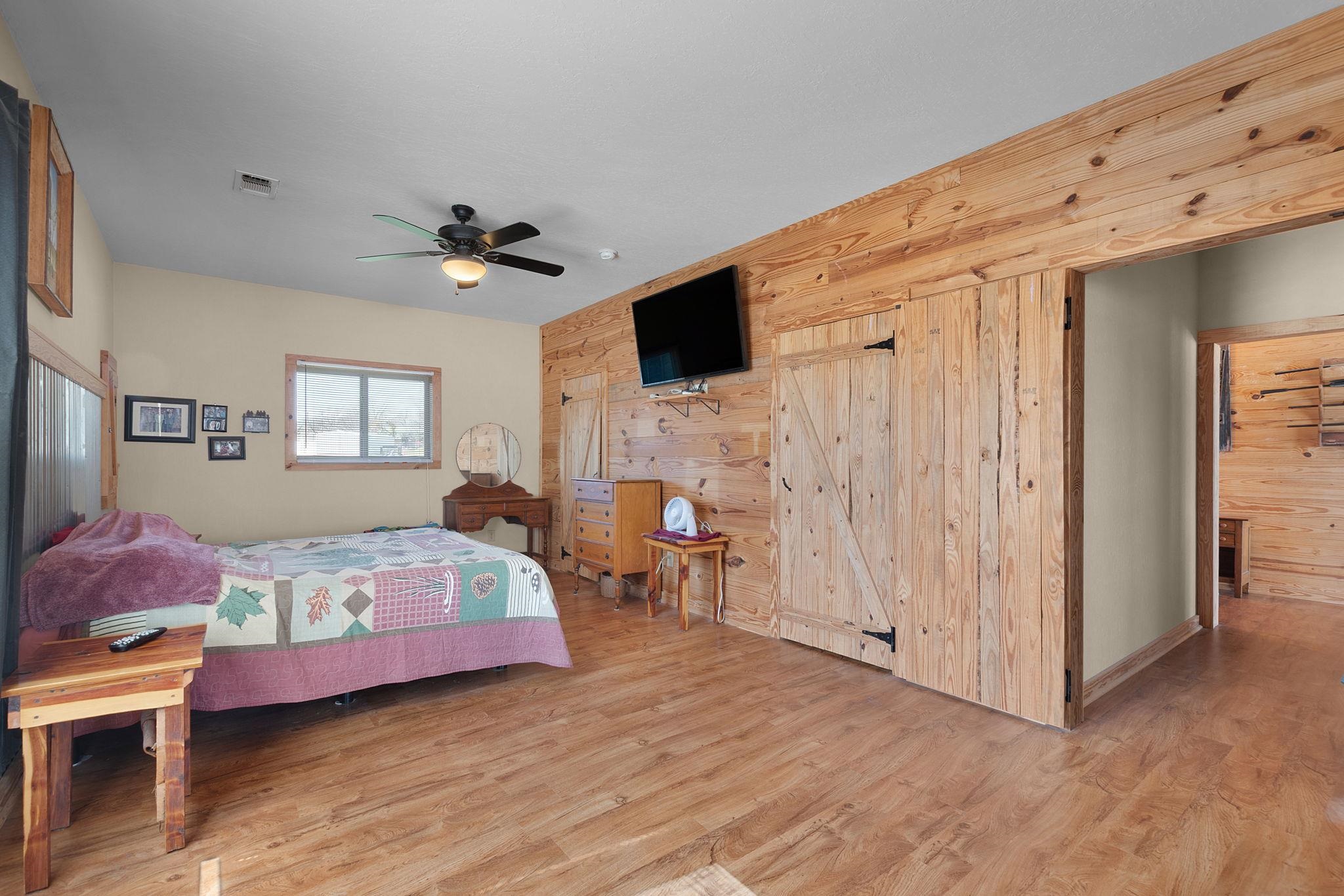303 Lakeshore Loop Tow, TX 78672 - Photo 21 of 30 a spacious bedroom with a bed and a chandelier