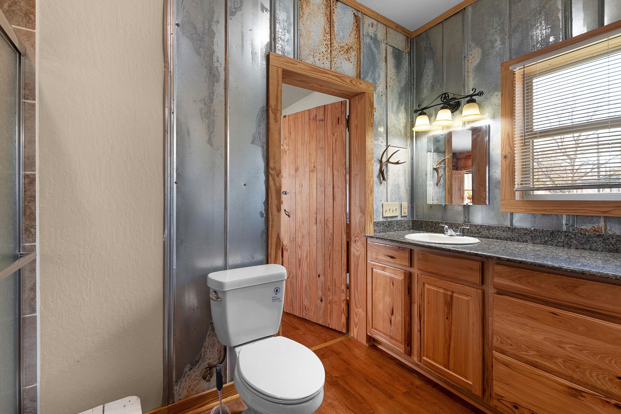 303 Lakeshore Loop Tow, TX 78672 - Photo 23 of 30 a bathroom with a granite countertop toilet sink and mirror