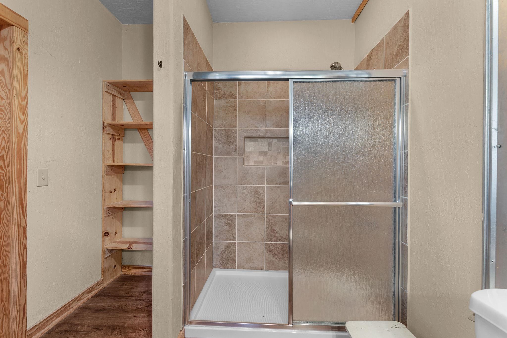 303 Lakeshore Loop Tow, TX 78672 - Photo 24 of 30 a bathroom with a glass shower door