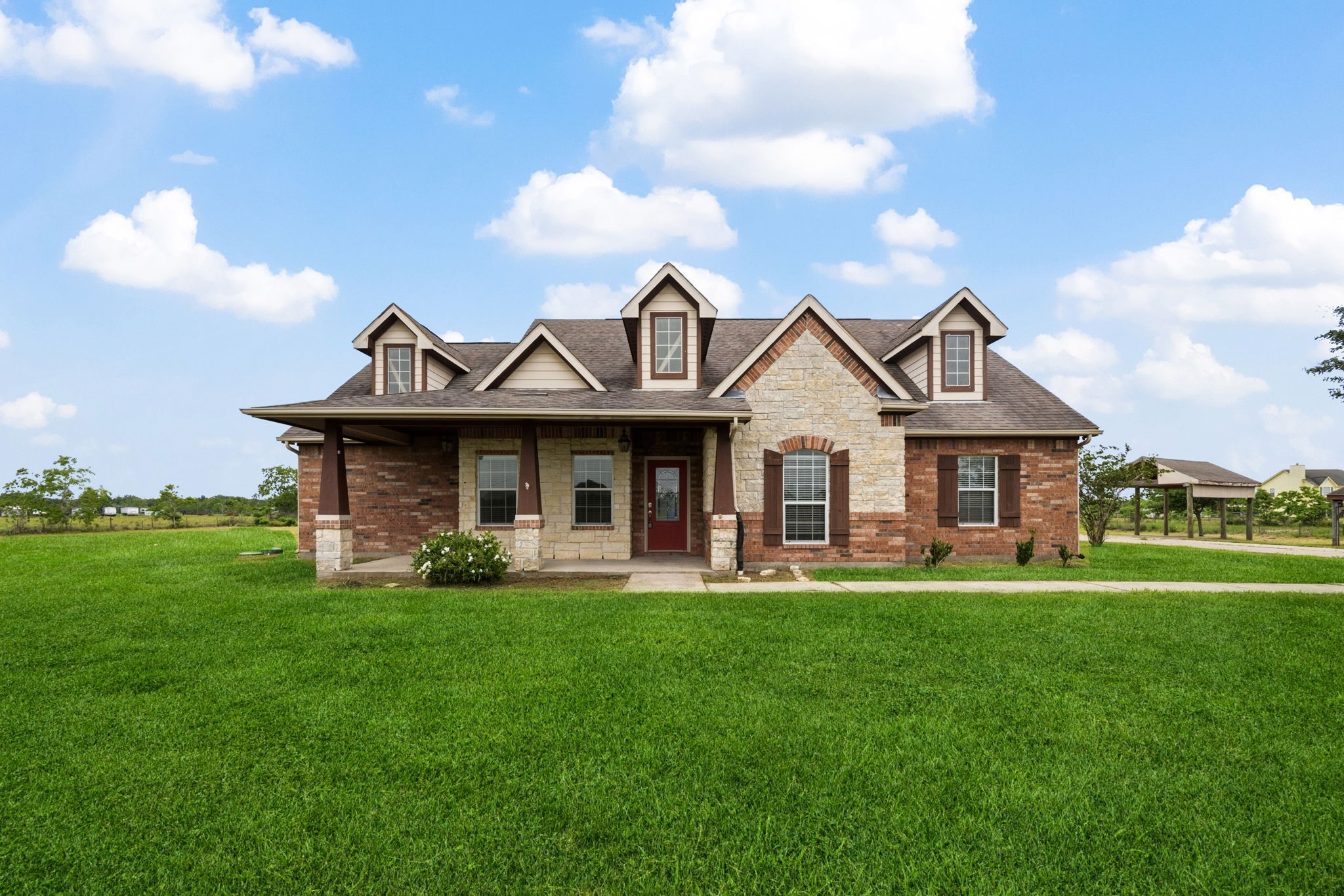 1405 Big Hill Road Winnie, TX 77665 - Photo 16 of 43 a front view of a house with a garden and yard