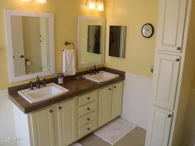 a bathroom with double vanity sink and a mirror