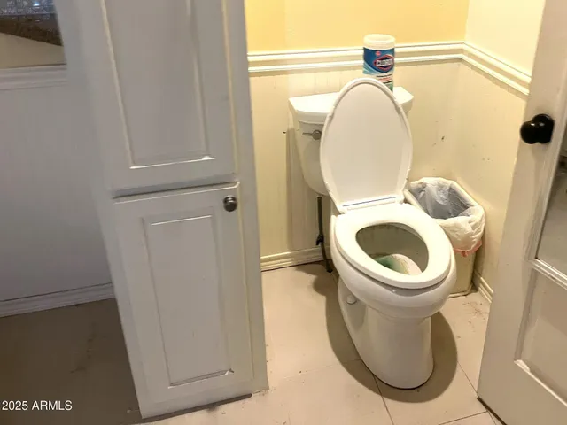 a bathroom with a toilet and a mirror