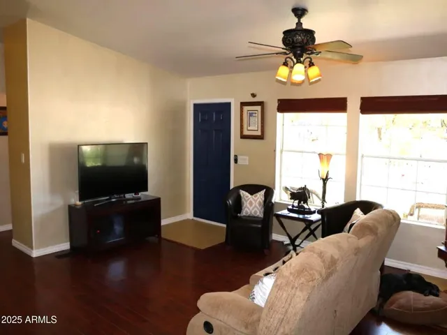 a living room with furniture a chandelier and a flat screen tv