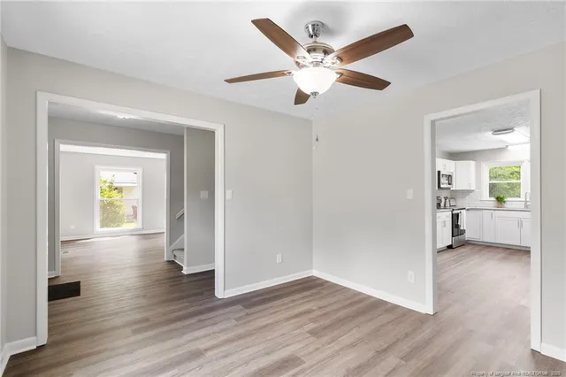 a view of a livingroom with wooden floor and a ceiling fan
