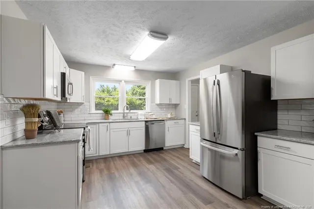 a kitchen with a refrigerator stove top oven and sink
