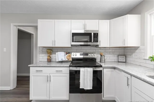 a kitchen with white cabinets and stainless steel appliances