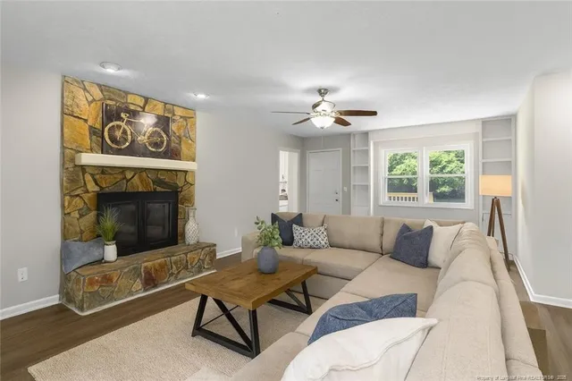 a living room with furniture a fireplace and a flat screen tv