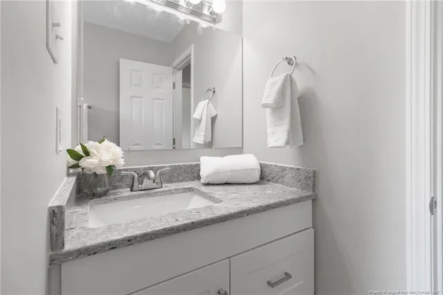 a bathroom with a granite countertop sink and a mirror