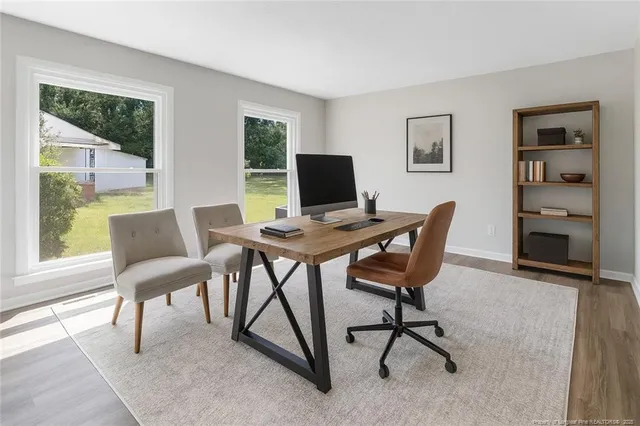a view of a workspace with furniture and a window