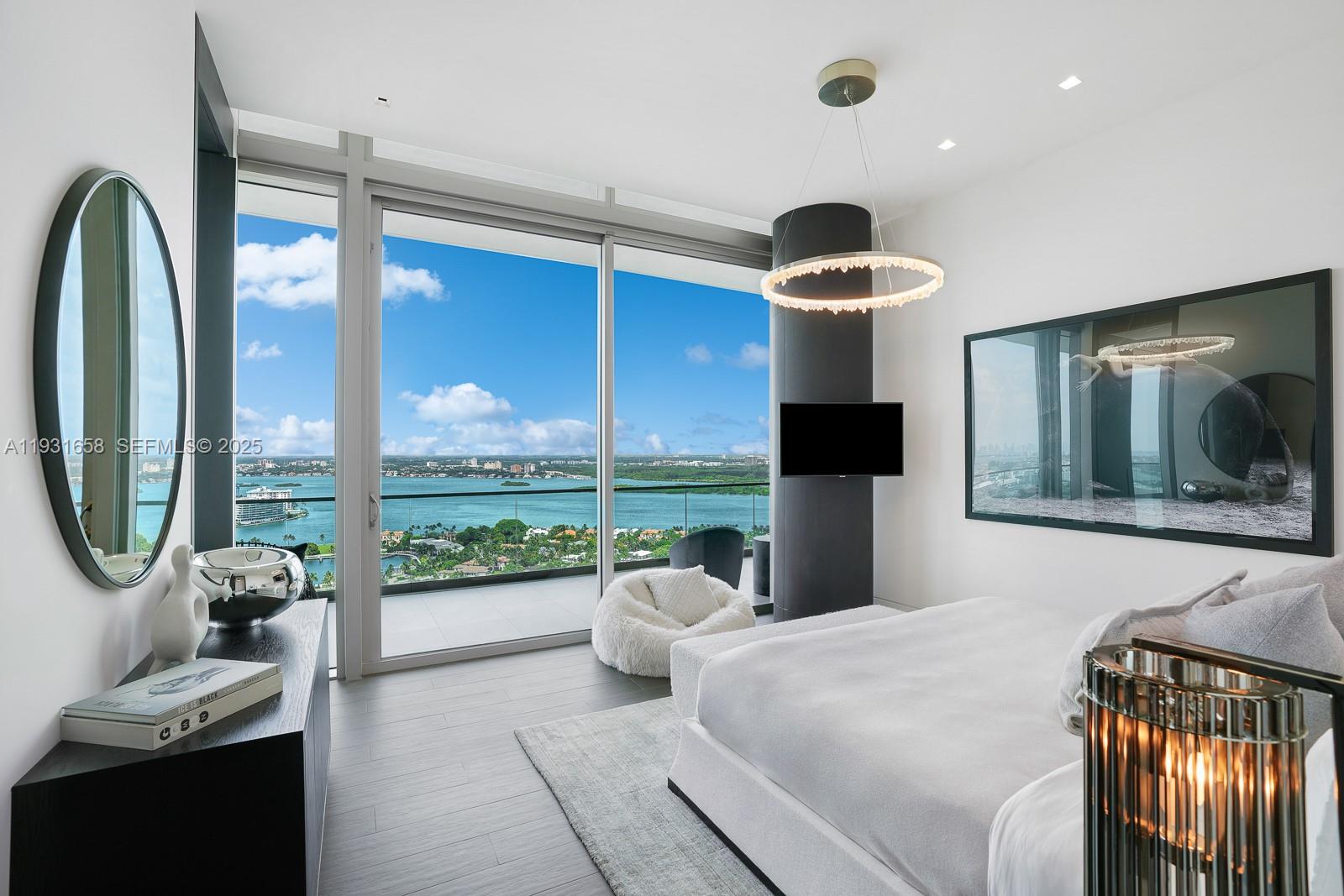 10203 Collins Avenue, Unit 2801 Bal Harbour, FL 33154 - Photo 38 of 60 a bedroom with a bed and a floor to ceiling window