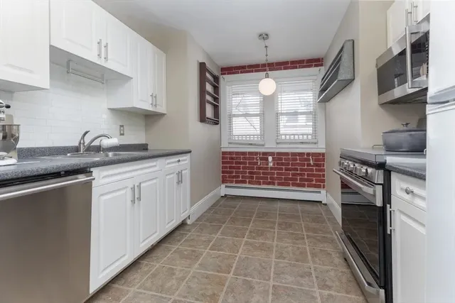 a kitchen with stainless steel appliances a sink stove top oven and cabinets