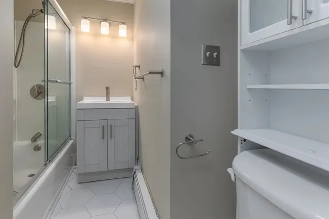 a bathroom with a sink a toilet and shower