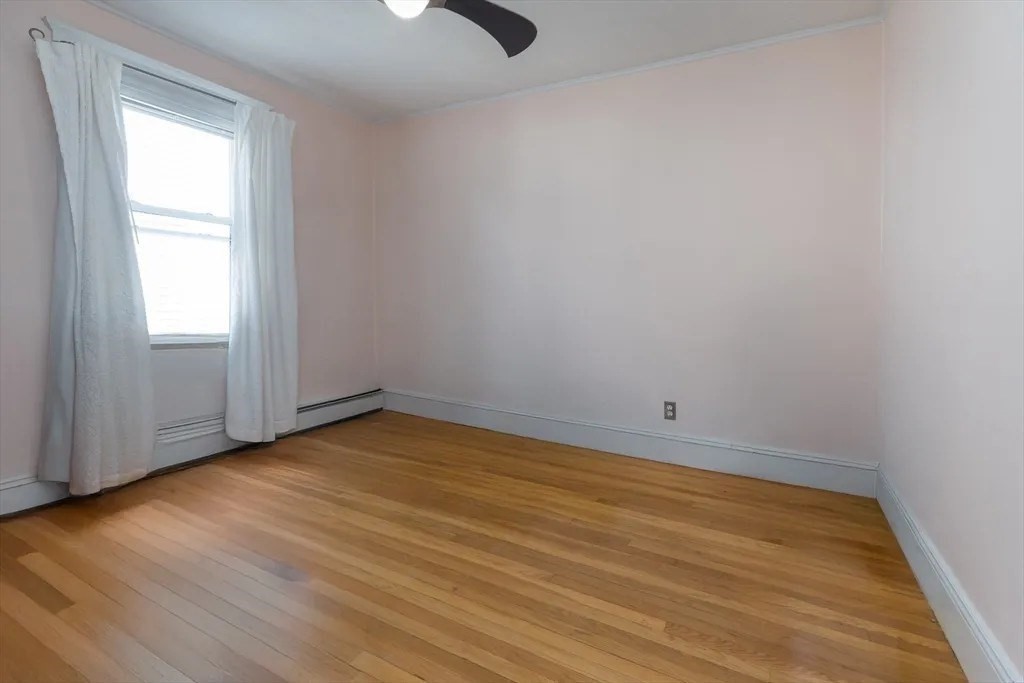121 Johnson Street, Unit 3L Lynn, MA 01902 - Photo 9 of 10 an empty room with wooden floor cabinet and windows