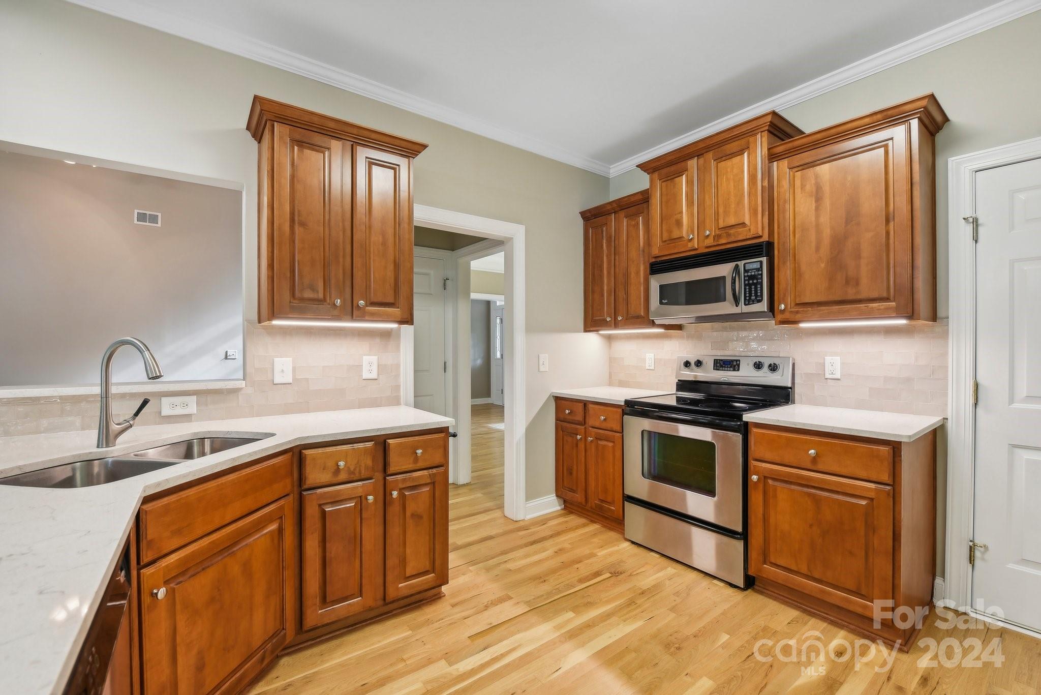 1013 Wesley Downs Road Monroe, NC 28110 - Photo 11 of 41 a kitchen with stainless steel appliances granite countertop a sink stove microwave and refrigerator