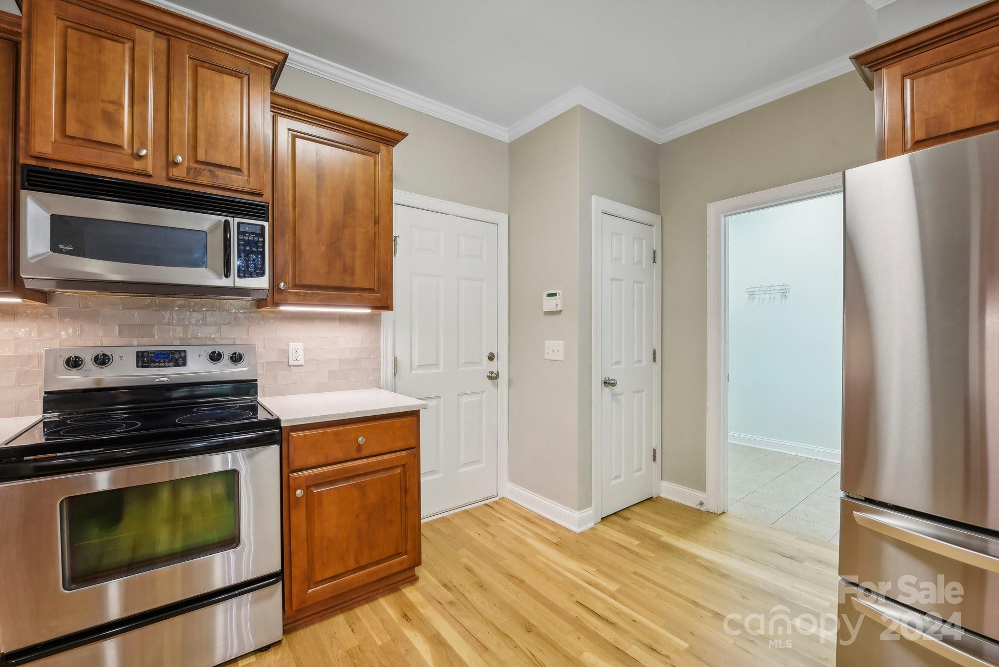 1013 Wesley Downs Road Monroe, NC 28110 - Photo 12 of 41 a kitchen with stainless steel appliances granite countertop a stove microwave and refrigerator