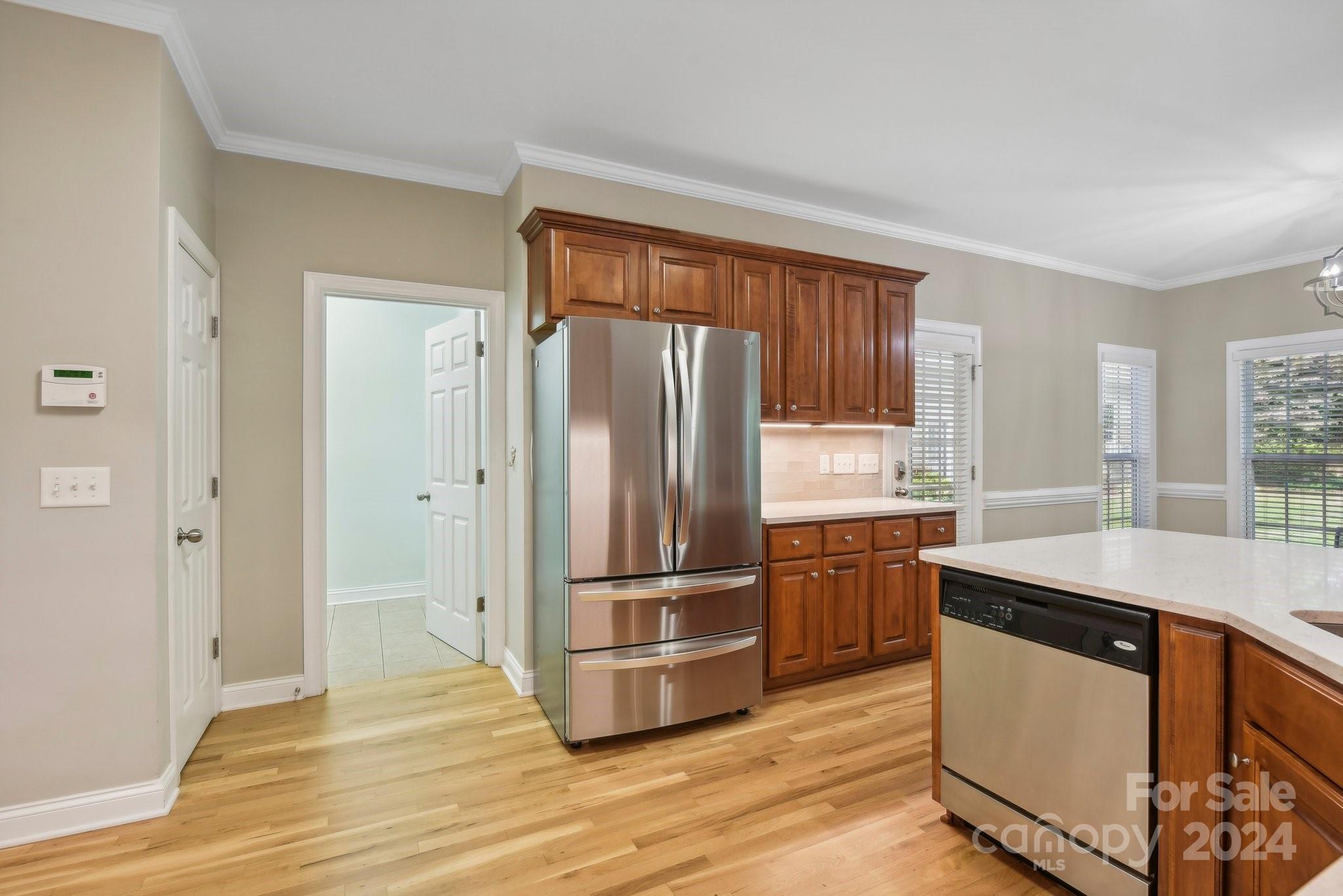 1013 Wesley Downs Road Monroe, NC 28110 - Photo 14 of 41 a kitchen with a refrigerator sink and wooden floor