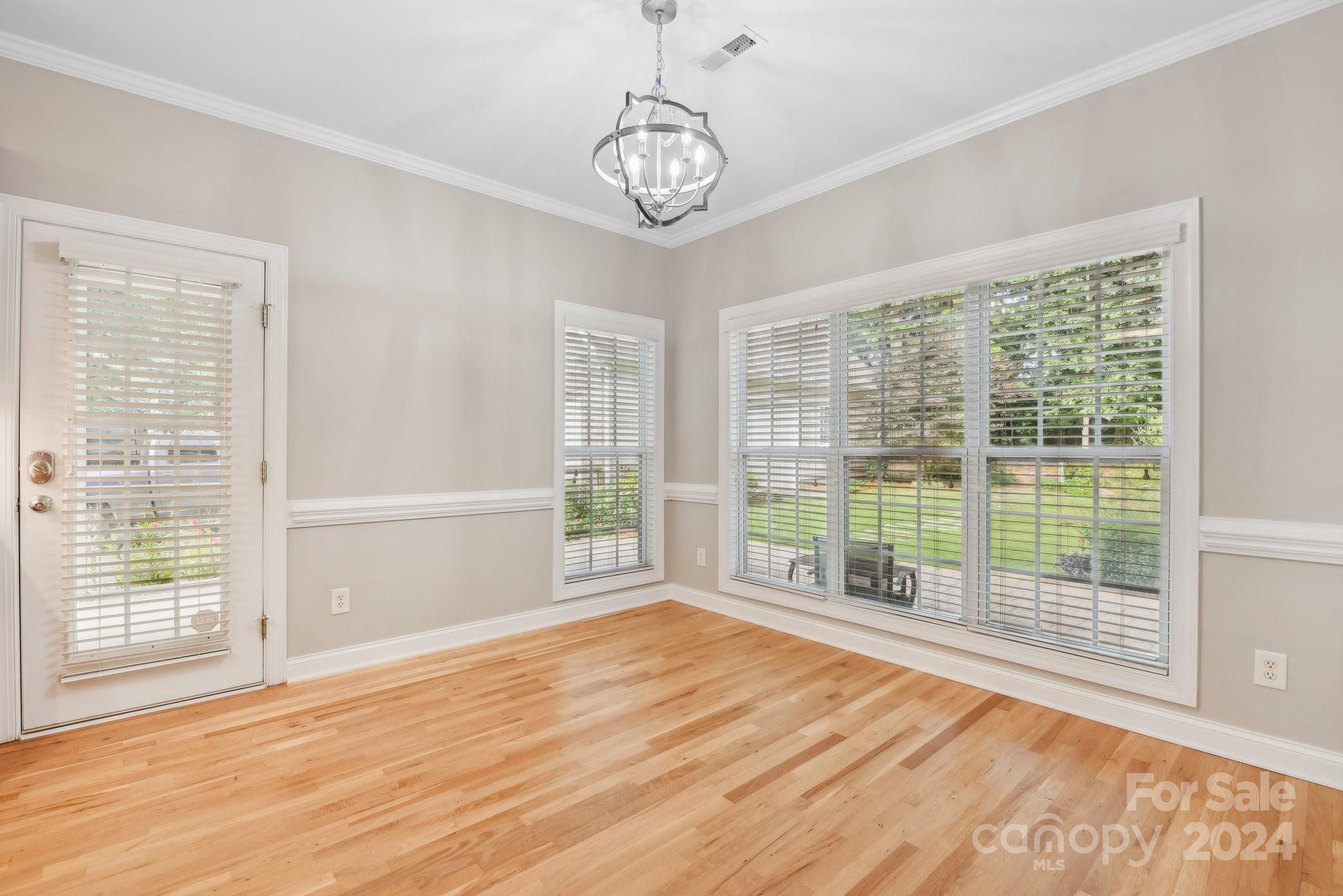 1013 Wesley Downs Road Monroe, NC 28110 - Photo 16 of 41 a view of an empty room with wooden floor and a window