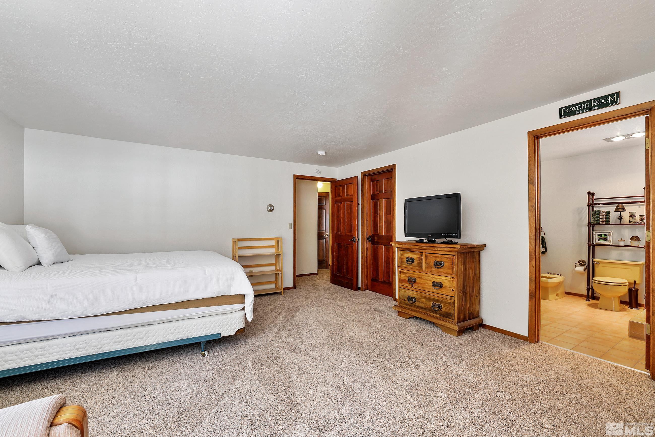 84 Rubicon Circle North, Unit C Stateline, NV 89449 - Photo 12 of 22 a bedroom with a bed and a flat tv screen on dresser