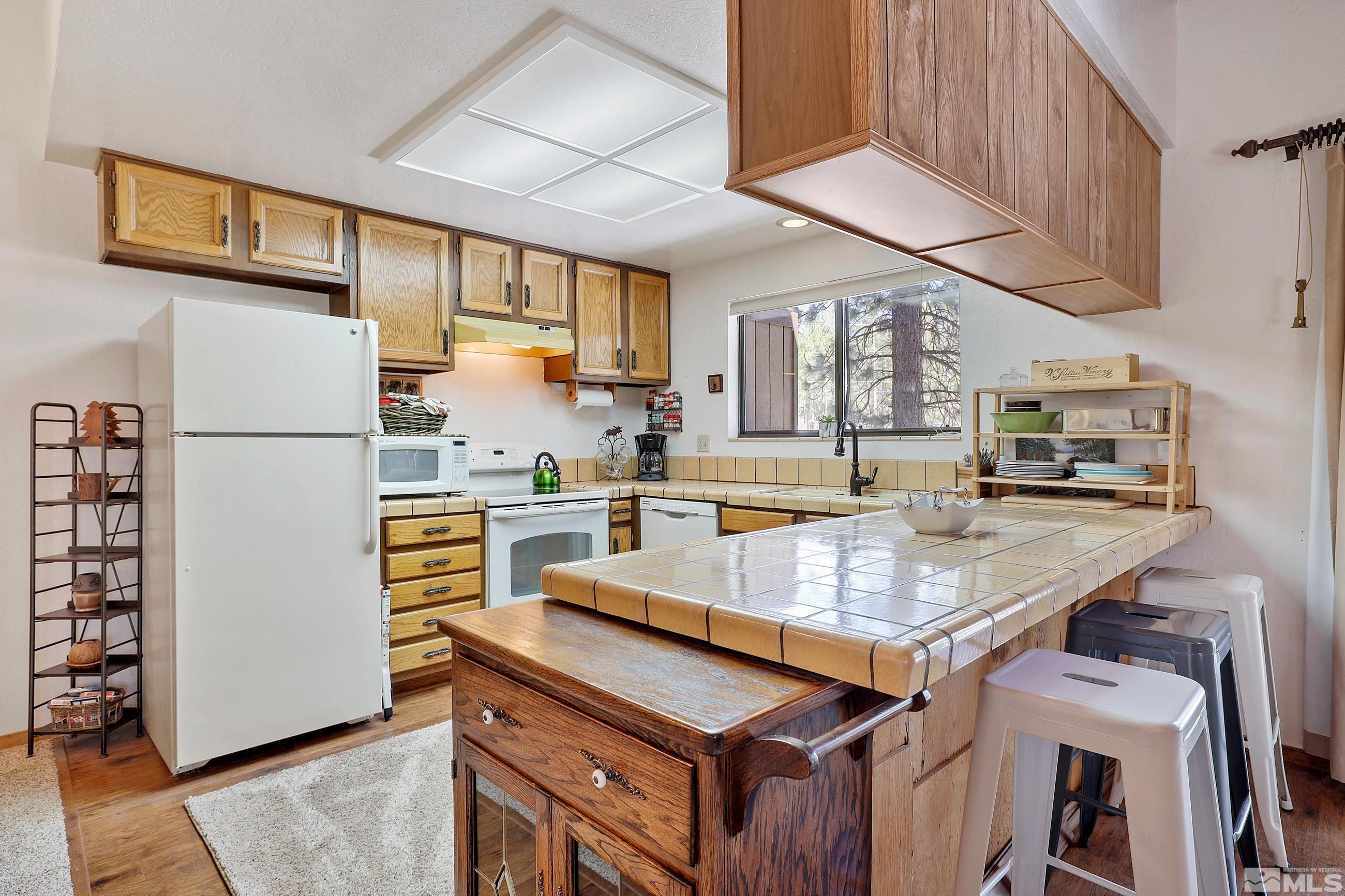 84 Rubicon Circle North, Unit C Stateline, NV 89449 - Photo 8 of 22 a kitchen with stainless steel appliances granite countertop a refrigerator a stove and a sink with cabinets