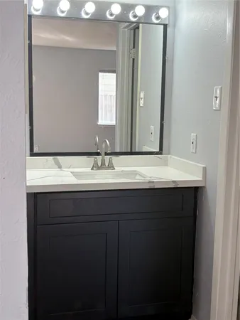 a bathroom with a sink vanity and a mirror