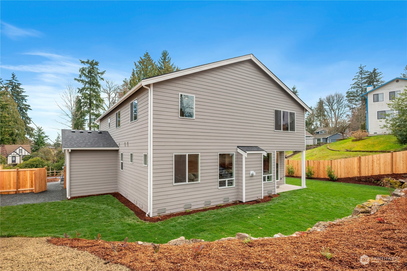 24230 Brier Road Brier, WA 98036 - Photo 35 of 40 a view of a white house next to a yard with big trees