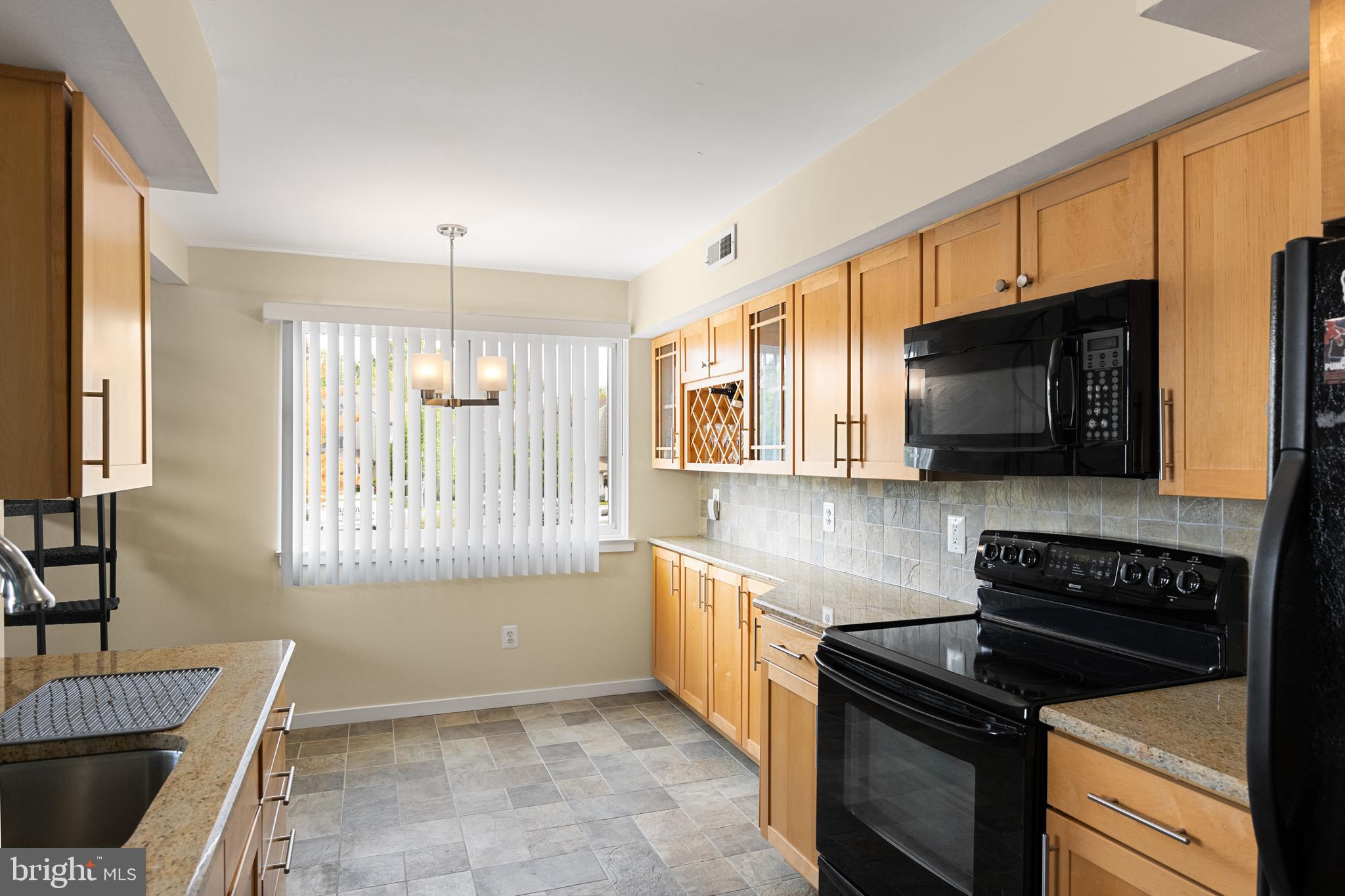 2208 Sandra Road Voorhees, NJ 08043 - Photo 10 of 28 a kitchen with granite countertop a stove a sink and a microwave