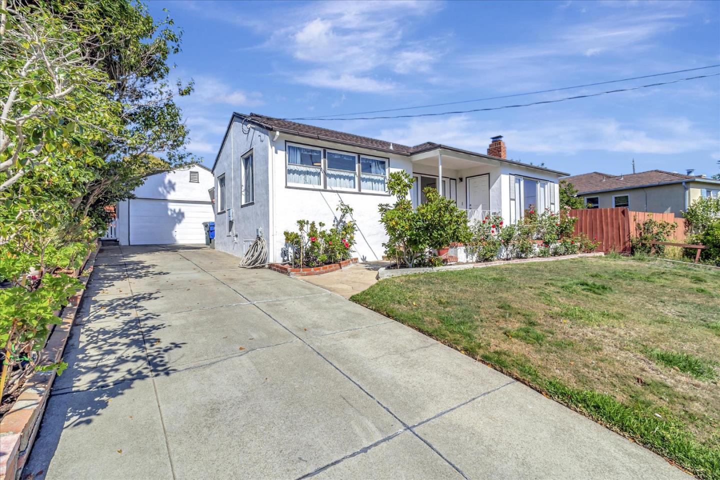 a front view of a house with a yard and potted plants