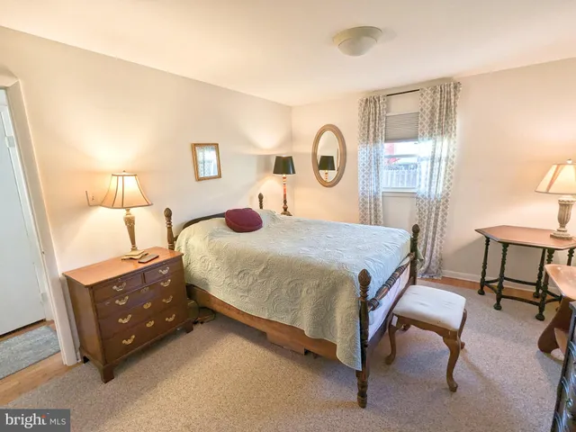 a bedroom with a bed and a lamp next to a window