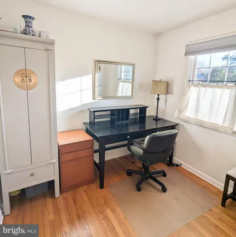 a view of a workspace with furniture and a window