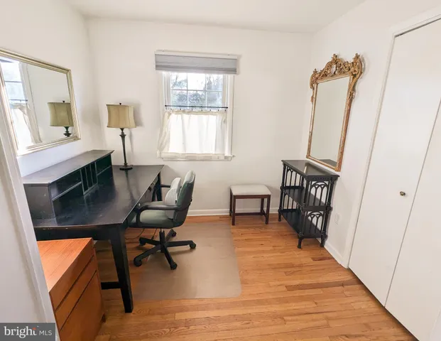 a view of a workspace with furniture and a window