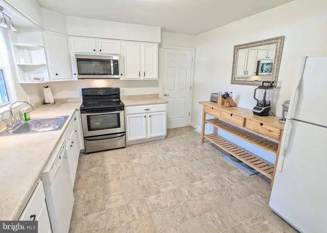 a kitchen with stainless steel appliances a stove refrigerator sink and cabinets