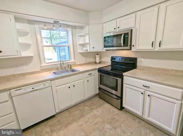 a kitchen with white cabinets and white appliances