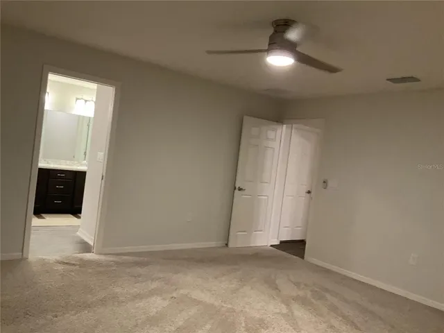 an empty room with closet and a bathroom