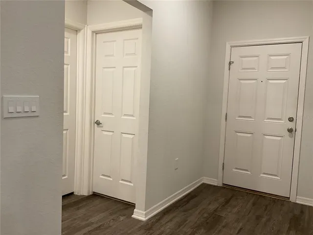 an empty room with wooden floor and closet area