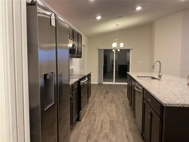 a bathroom with a granite countertop sink a large mirror and a refrigerator