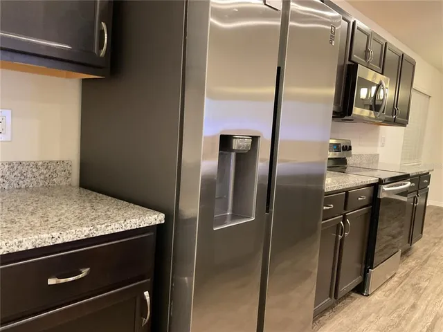 a metallic refrigerator freezer sitting inside of a kitchen