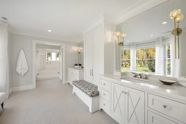 a spacious bathroom with a granite countertop sink a mirror and a bathtub