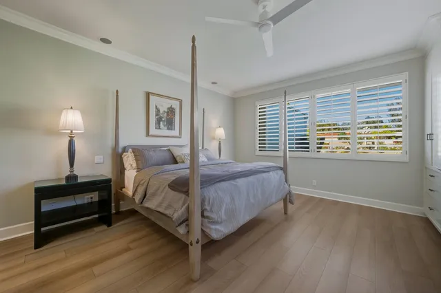 a bedroom with a large bed a flat tv screen and large windows