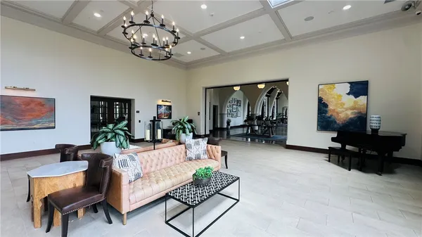 a living room with furniture a chandelier and a flat screen tv