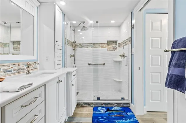 a bathroom with a shower sink and mirror